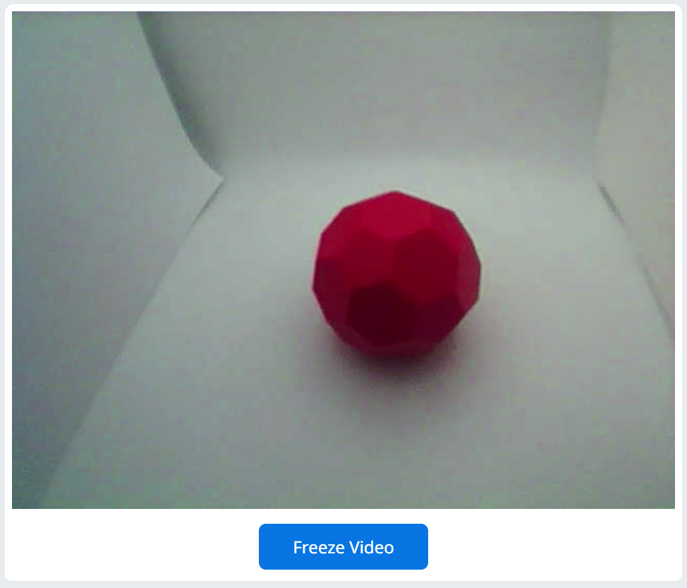 Nguồn cấp dữ liệu video của AI Vision Utility được hiển thị sau khi thiết lập lại và một Buckyball màu đỏ nằm trong tầm nhìn của cảm biến. Bây giờ video không còn màu nữa. Nền trắng trông có màu trắng và quả bóng Buckyball màu đỏ trông có màu đỏ.