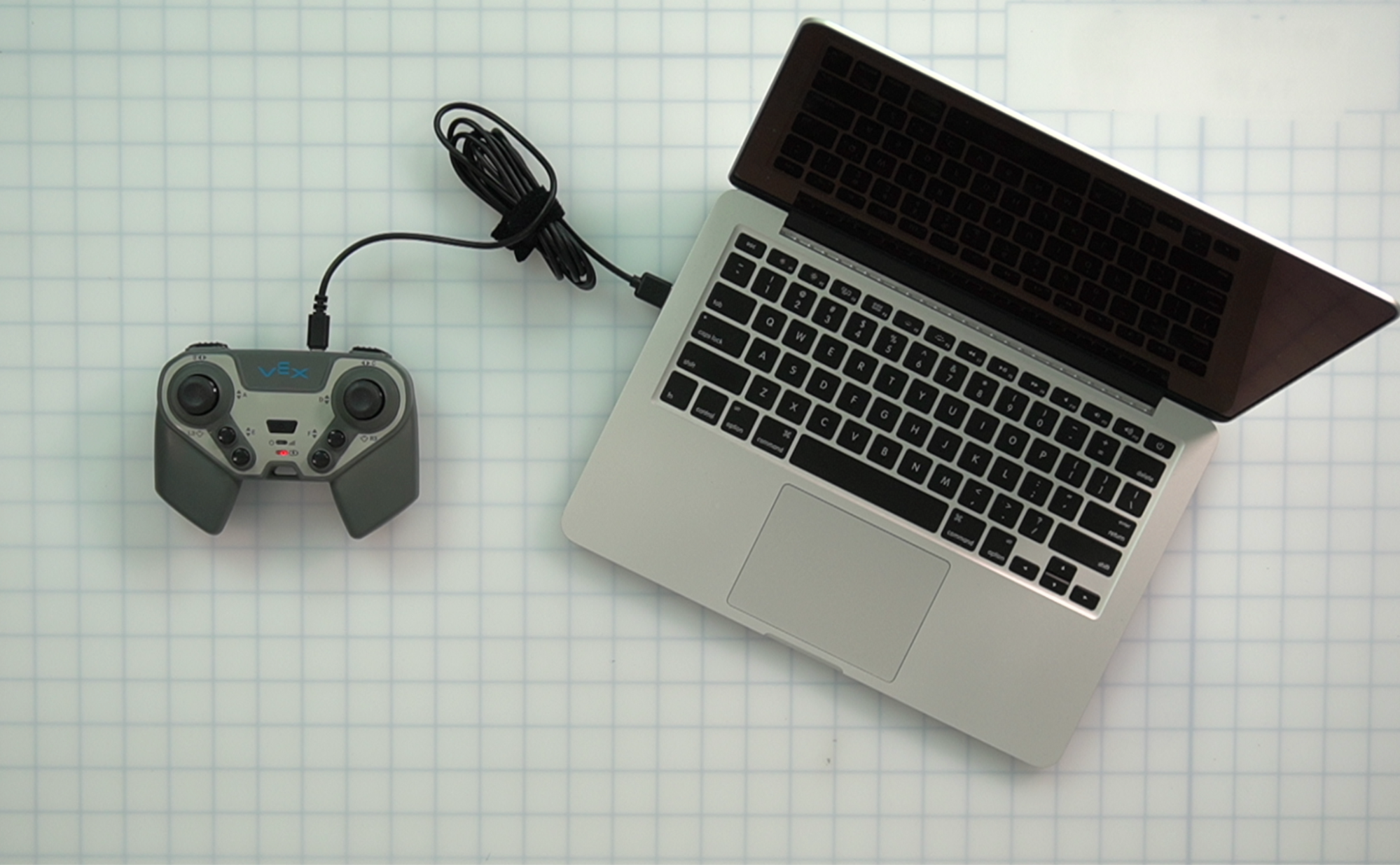 একটি USB C কেবলের মাধ্যমে সংযুক্ত একটি ল্যাপটপ এবং নিয়ামকের উপরে নিচে।