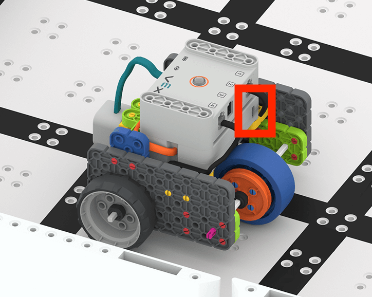 Code Base 2.0 podczas jazdy po polu GO. Port ładowania akumulatora znajduje się z tyłu robota, w łatwo dostępnym miejscu i jest oznaczony czerwoną ramką.