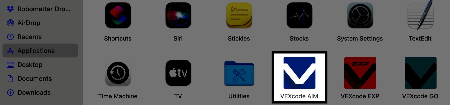 Screenshot of the Mac Applications folder showing the VEXcode AIM application icon highlighted in red, along with other applications like VEXcode 123, VEXcode GO, and more.