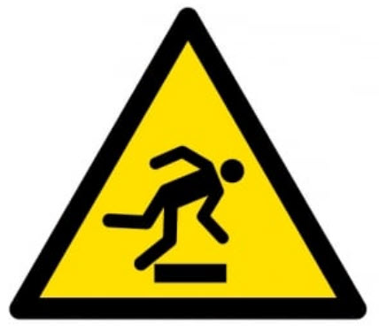 Yellow hazard symbol with a diagram of a person tripping over an object.