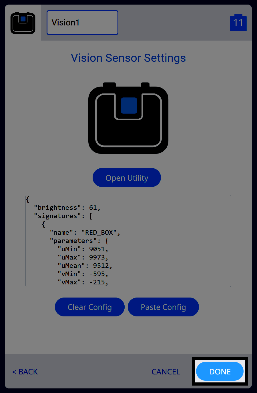The same Vision Sensor Settings screen, now with the configuration JSON pasted into the text field. The JSON includes brightness and RED_BOX signature parameters. The Done button at the bottom right is highlighted, indicating the configuration is ready to be applied.