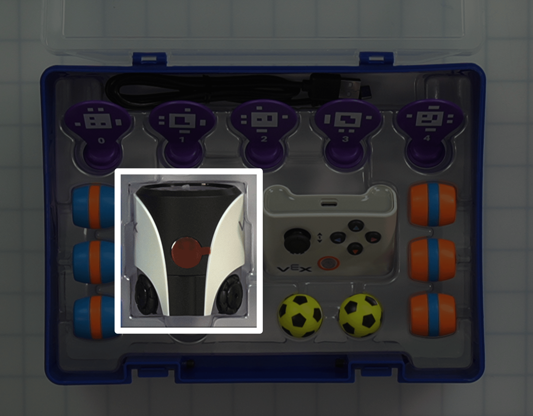 A top down view of an open AIM Kit, with the robot highlighted in the center left side of the box.
