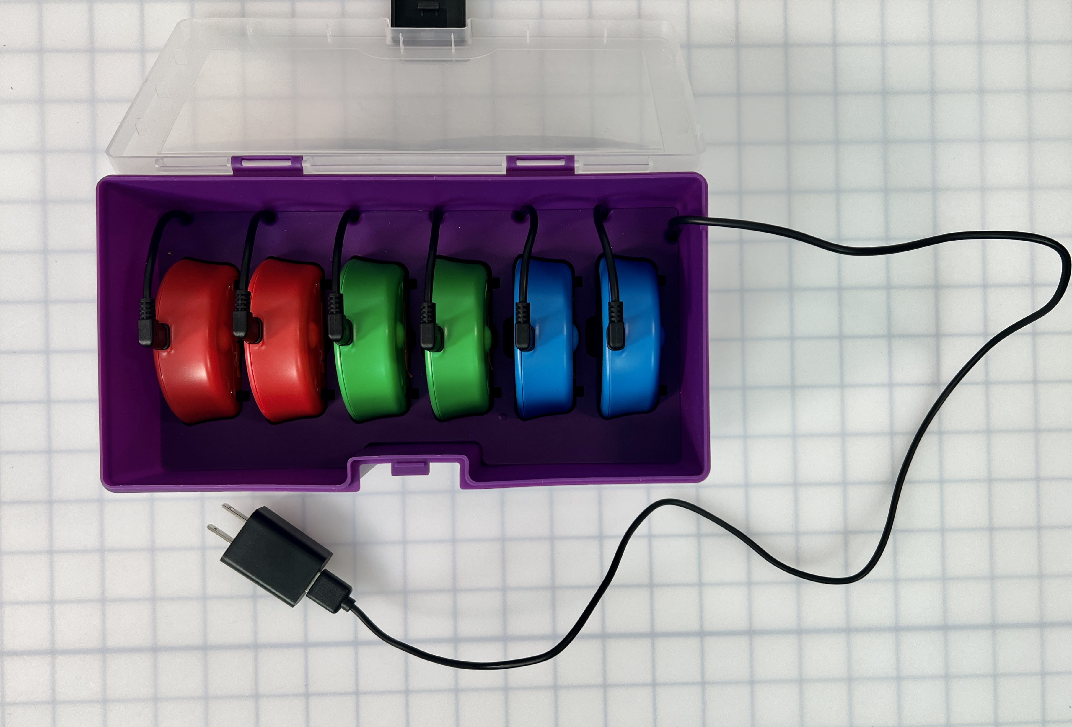 6 123 Robots en un estuche de almacenamiento con sus puertos de carga hacia arriba y enchufados utilizando los cables de carga del estuche de almacenamiento.