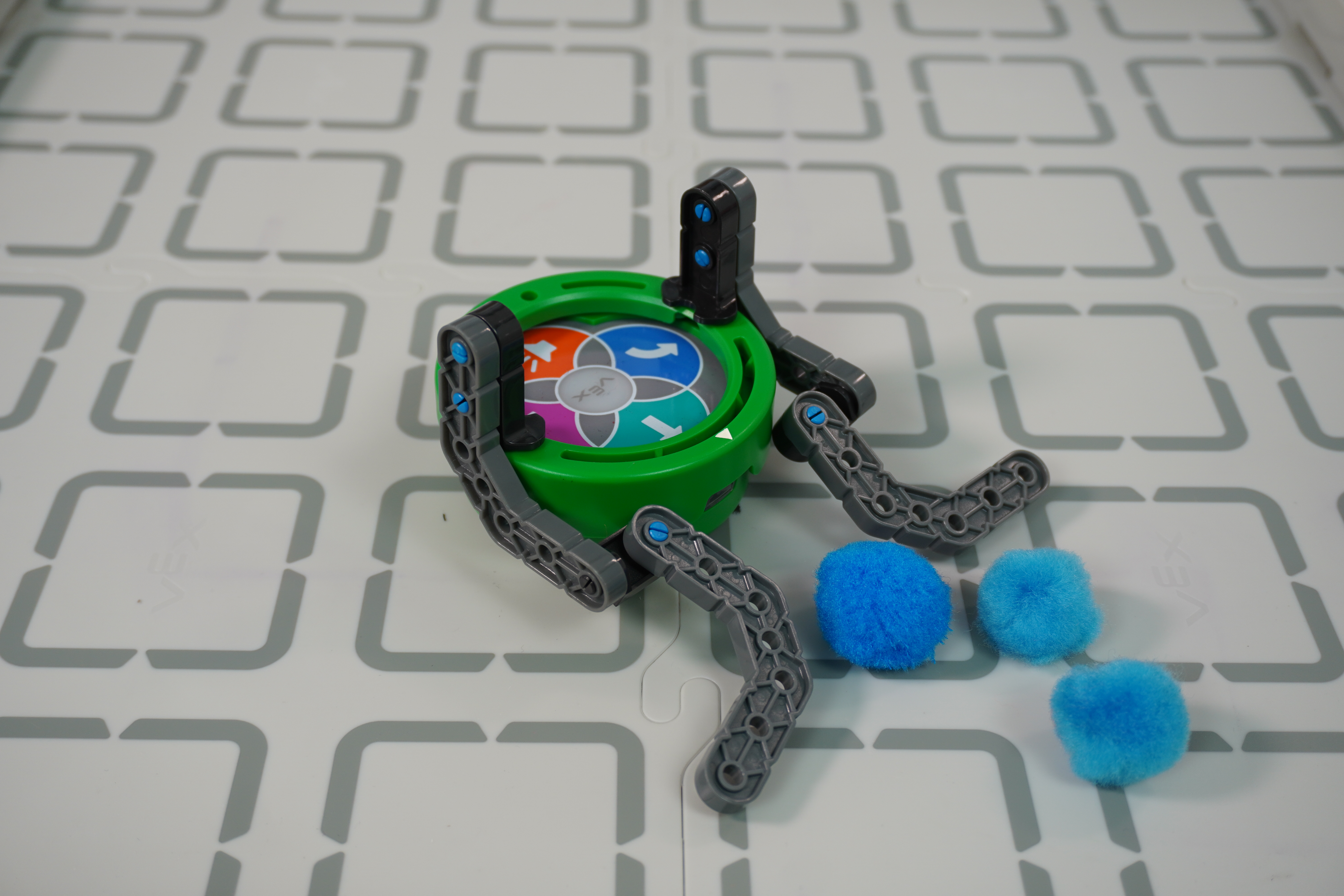 Úhlový pohled na příklad VEX Pieces designu vozidla na čištění pom pom připojeného k Art Ringu.