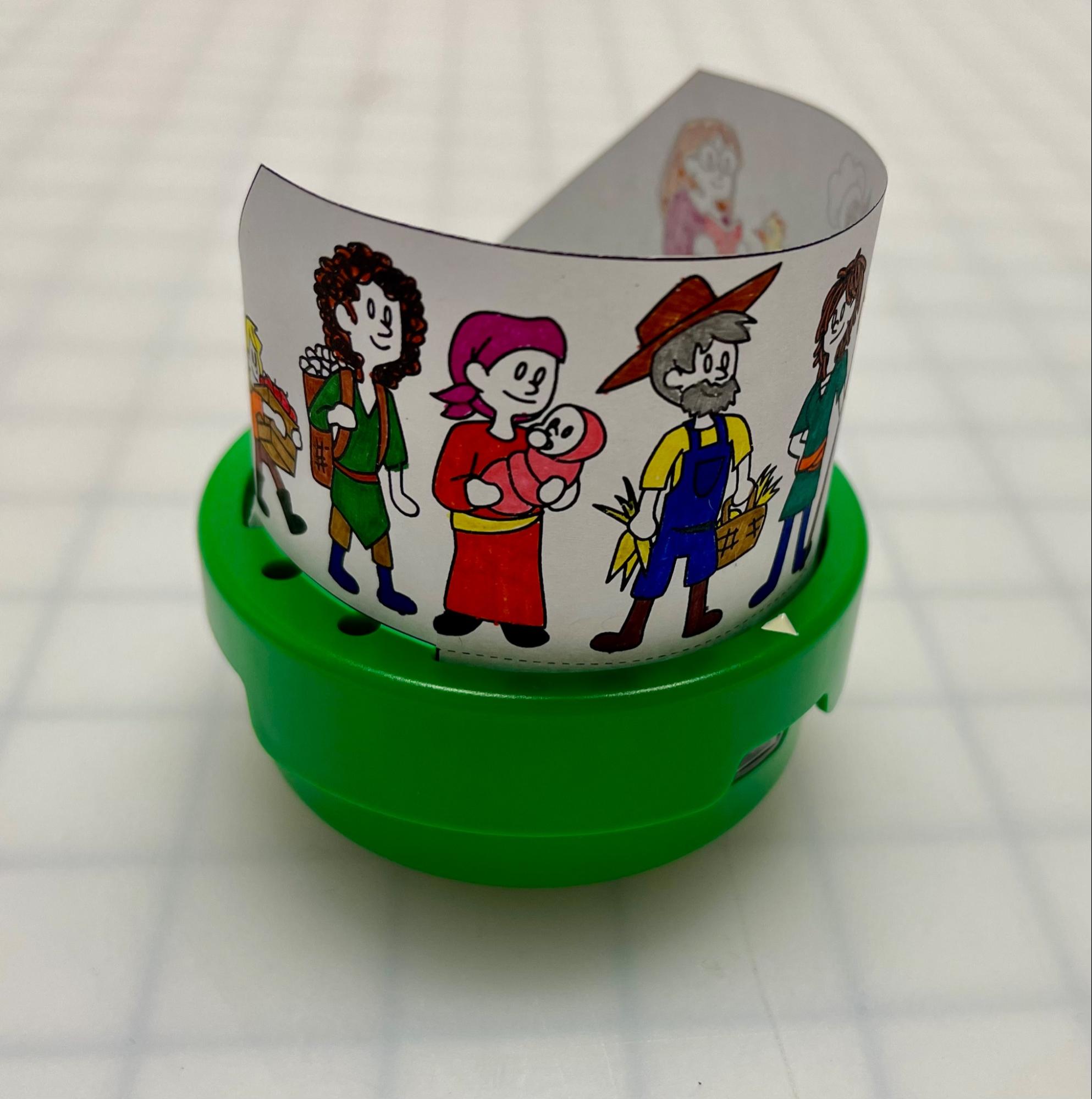 Közelkép az Art Ring vászonról, amely az Art Ringhez és a 123 Robothoz van rögzítve, hogy demonstrálja a kész megjelenést. Egy sor karaktert rajzolnak a papír Art Ring Canvasra, hogy úgy nézzenek ki, mintha a robot tetején állnának.