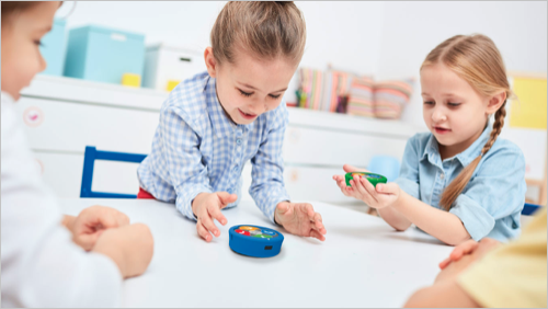 Alunos a interagir de forma colaborativa com um robô 123 em ambiente de sala de aula.