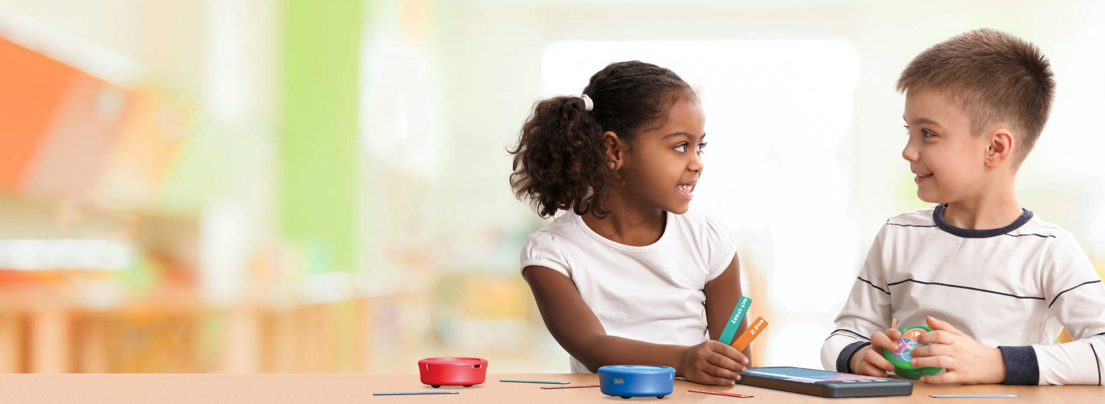 Estudiantes interactuando de forma colaborativa con un robot 123 y un codificador en un entorno de aula.