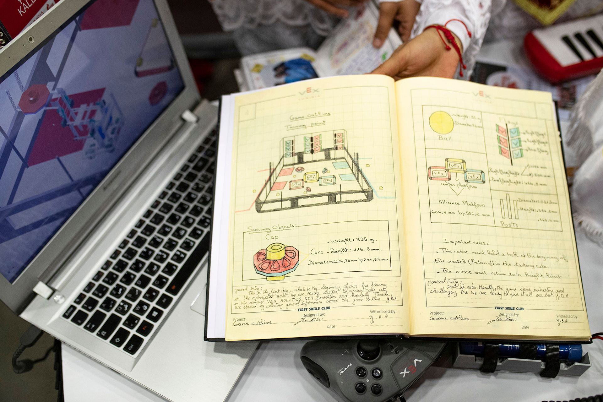 Um aluno escrevendo em um caderno de engenharia, demonstrando aprendizagem colaborativa e interação em um ambiente educacional focado em pesquisa e conceitos de engenharia.