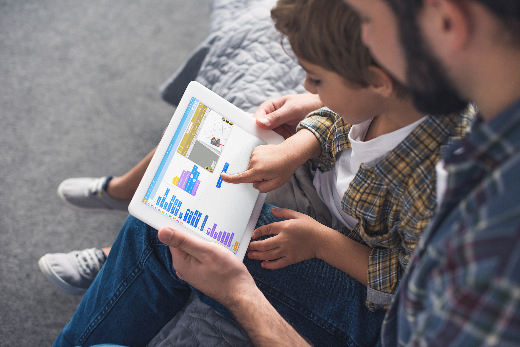 Un bambino interagisce con VEXcode VR su un tablet, dimostrando l'apprendimento interattivo della robotica e della programmazione in un contesto educativo.