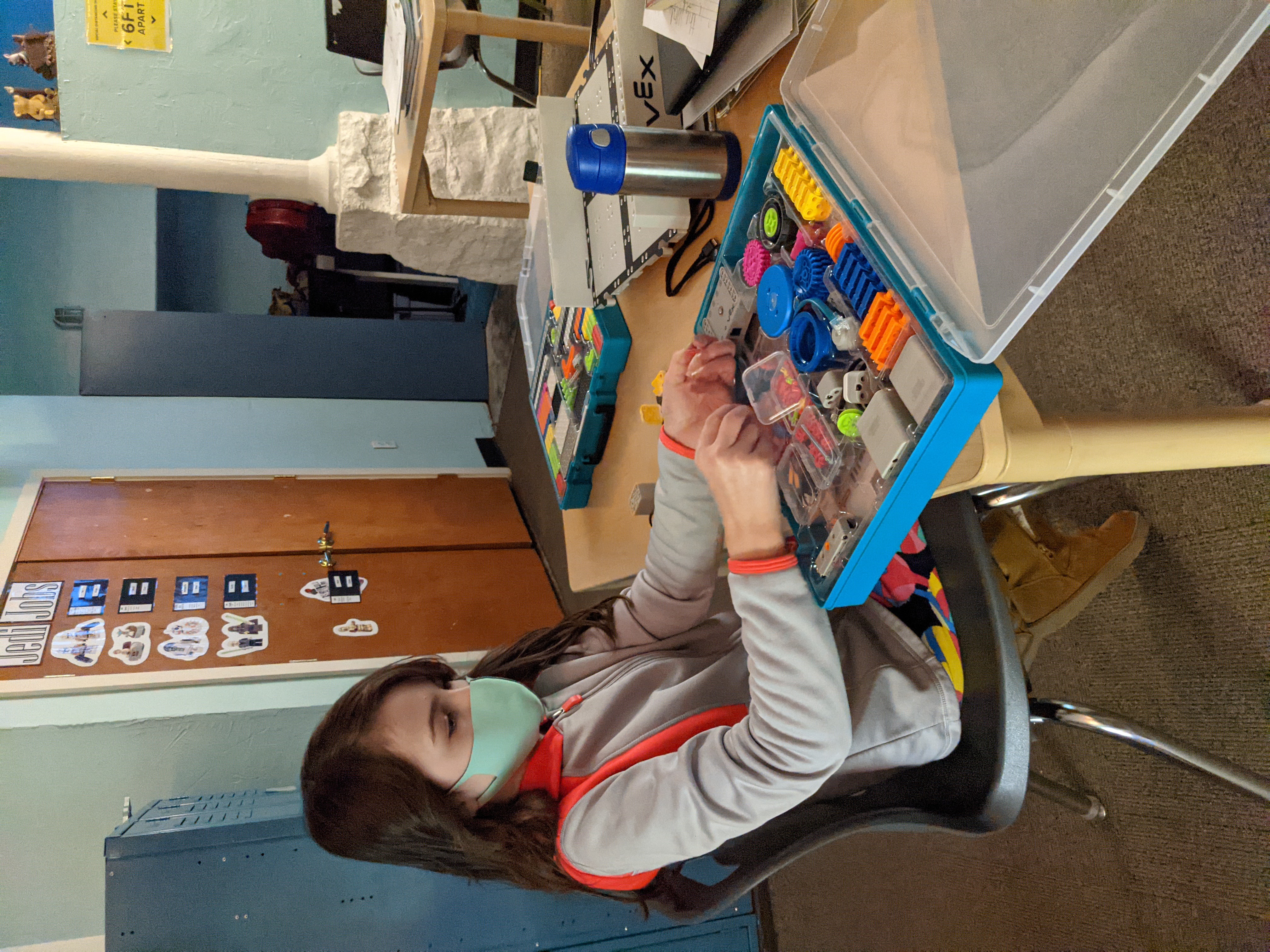 Ein Student beschäftigt sich in einem kleinen Arbeitsbereich mit dem VEX GO-Kit und demonstriert praxisorientiertes Lernen und Robotikunterricht.