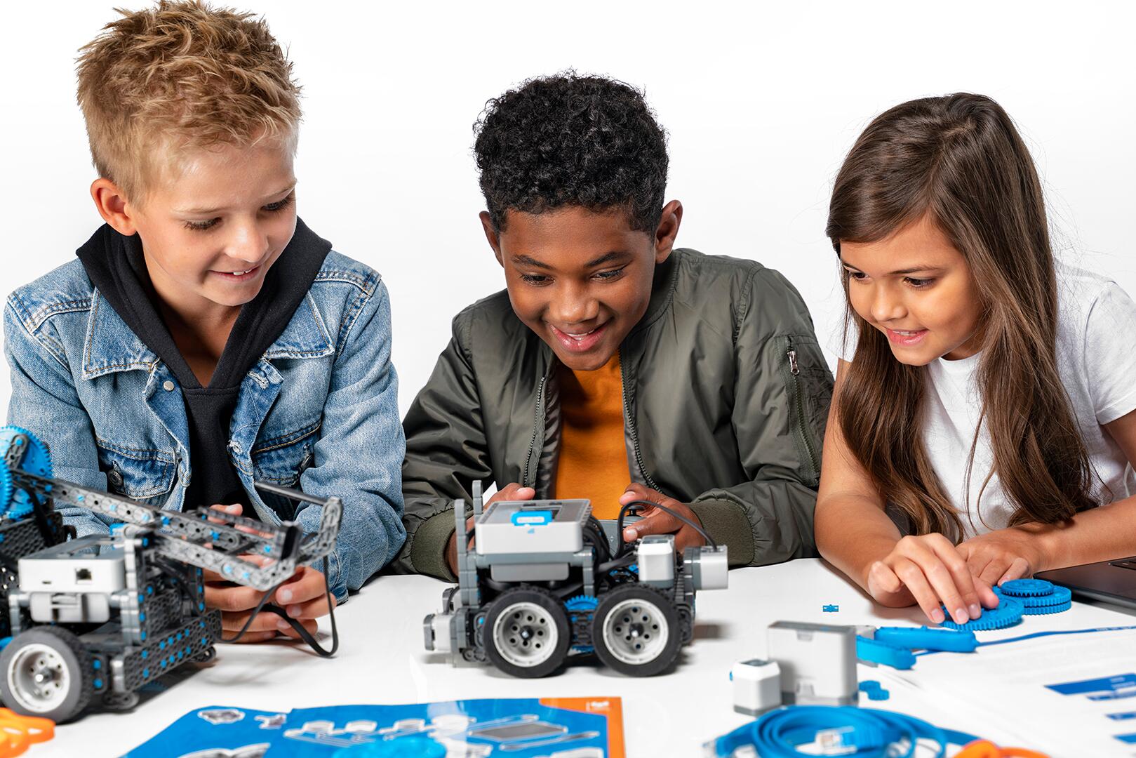 Componentes del kit de robótica VEX IQ exhibidos en una mesa, mostrando varias partes y herramientas para fines educativos en un entorno de aula, enfatizando el aprendizaje práctico y la colaboración en la educación STEM.