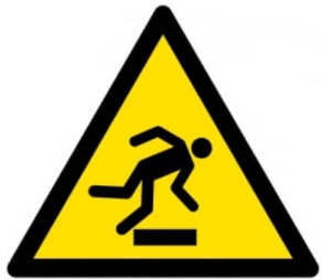 Symbole de danger jaune avec un schéma représentant une personne trébuchant sur un objet.