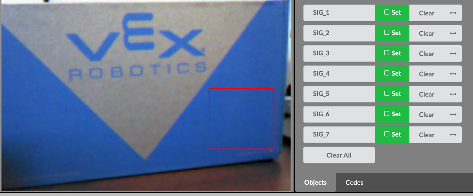 De live preview-feed van de Vision Sensor Utility toont een opbergdoos van VEX Robotics. Een gebied in de kleur blauw op het vak is geselecteerd met een rood vierkant. De Set-pictogrammen rechts naast de Handtekeningen zijn groen geworden.