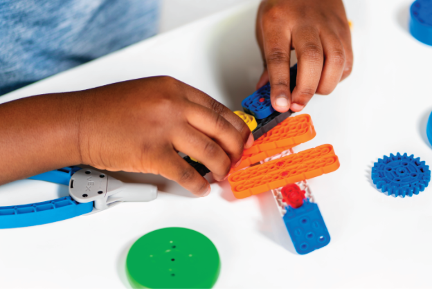 Estudiante en un entorno de aula creando un diseño original utilizando VEX GO Pieces.