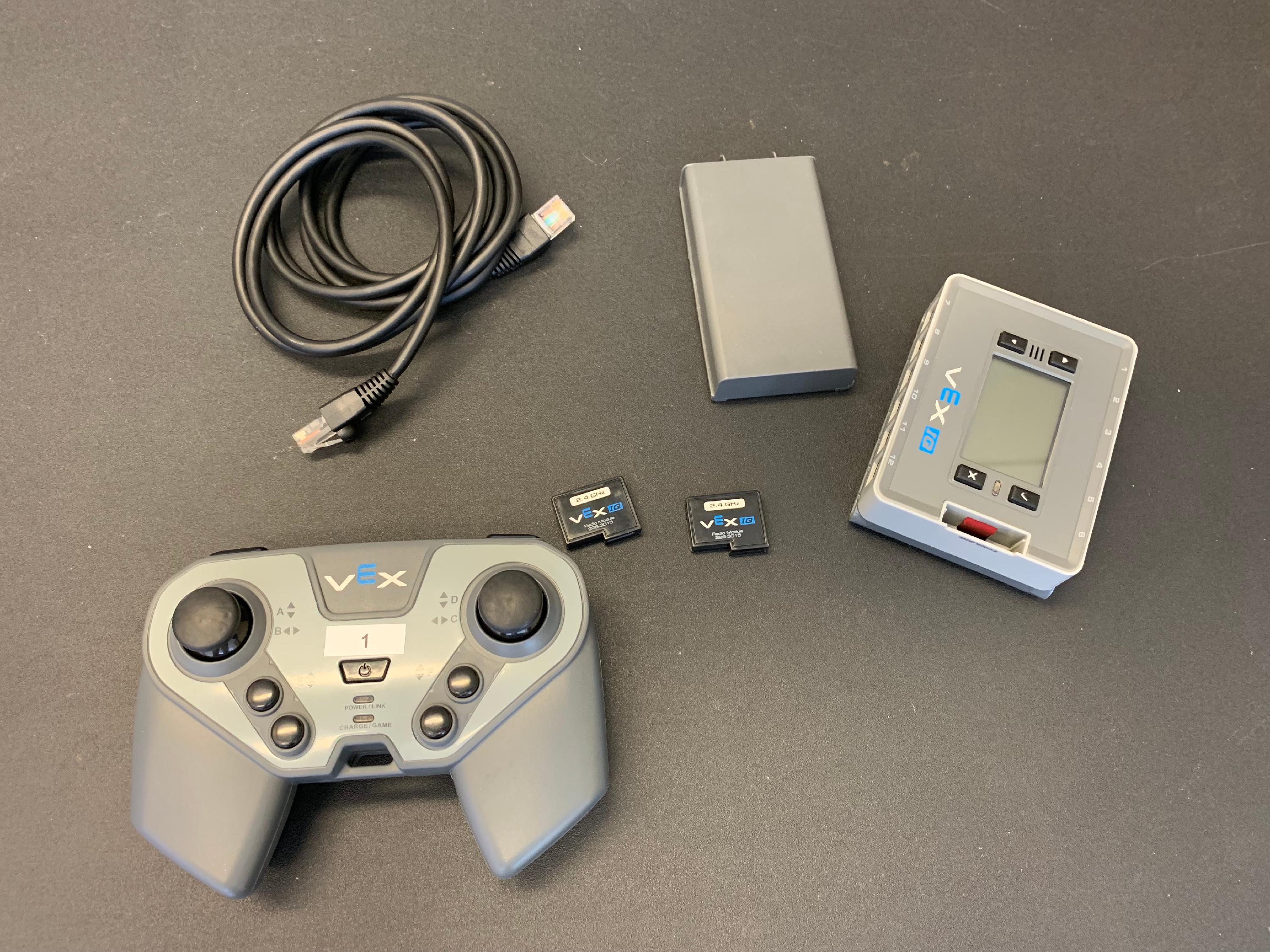 Controlador, cerebro, batería, cable de sujeción y dos radios a juego colocados juntos en una mesa.