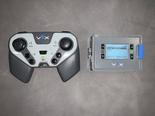 Controller neben einem Brain auf einem Tisch platziert, beide eingeschaltet und verbunden. In diesem Beispiel haben beide grüne Anzeigeleuchten.