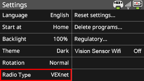 La pantalla del cerebro se muestra en el menú Configuración con la opción Tipo de radio resaltada. Este menú tiene muchas opciones que se pueden personalizar. Las opciones de esta captura de pantalla son Idioma inglés, Comenzar en casa, Retroiluminación 100%, Tema oscuro, Rotación normal y Tipo de radio VEXnet. También hay opciones del sistema a la derecha que leen Restablecer configuración, Eliminar programas, Regulatorio y Wifi del sensor de visión.