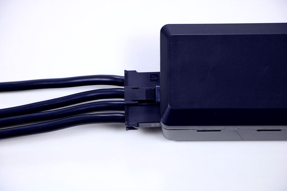 Le câble de batterie V5 est représenté connecté à une batterie de robot V5 via son port de câble de batterie.