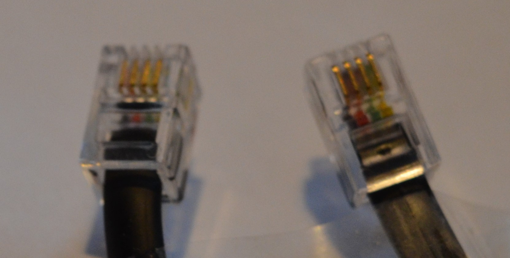 Primer plano de ambos extremos de un cable para resaltar que los conectores del cable están orientados uno frente al otro.