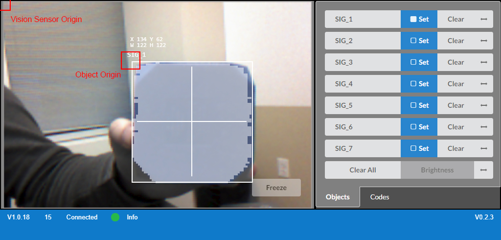 VEX V5 विज़न सेंसर का क्लोज-अप चित्र, जिसमें रोबोटिक्स अनुप्रयोगों के लिए उपयोग किए जाने वाले लेंस और माउंटिंग पॉइंट सहित इसके डिजाइन और विशेषताओं को दर्शाया गया है।