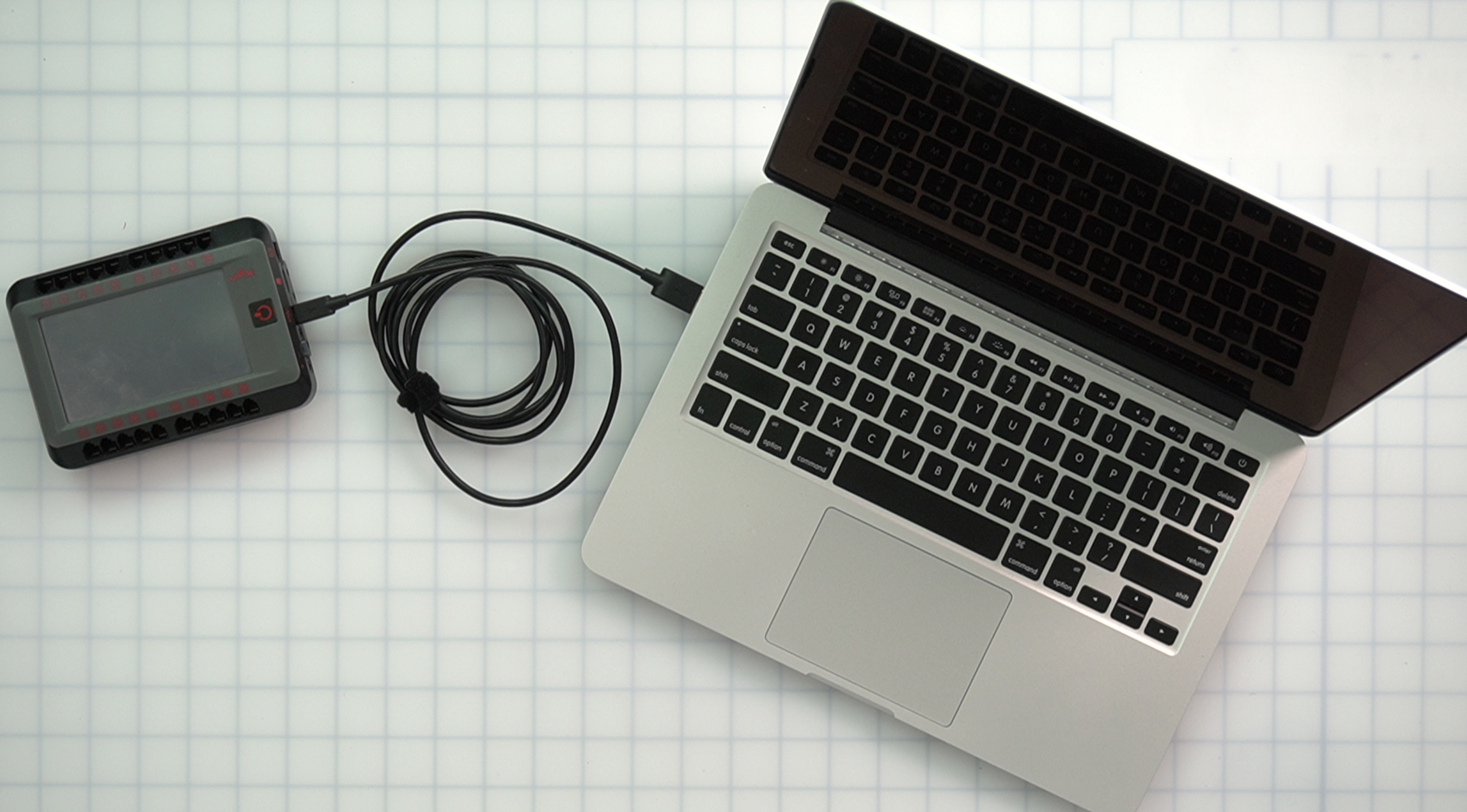 USB kablosuyla bir Mac bilgisayara bağlanan V5 robot beyni, programlama ve kontrol için bağlantı sürecini göstermektedir.