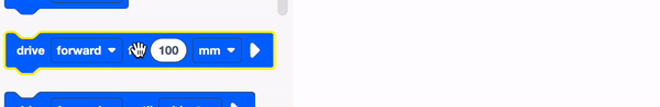 VEXcode GO Drive untuk blok diseret dari Toolbox ke Workspace. Blok tersebut bertuliskan Maju sejauh 100 mm.
