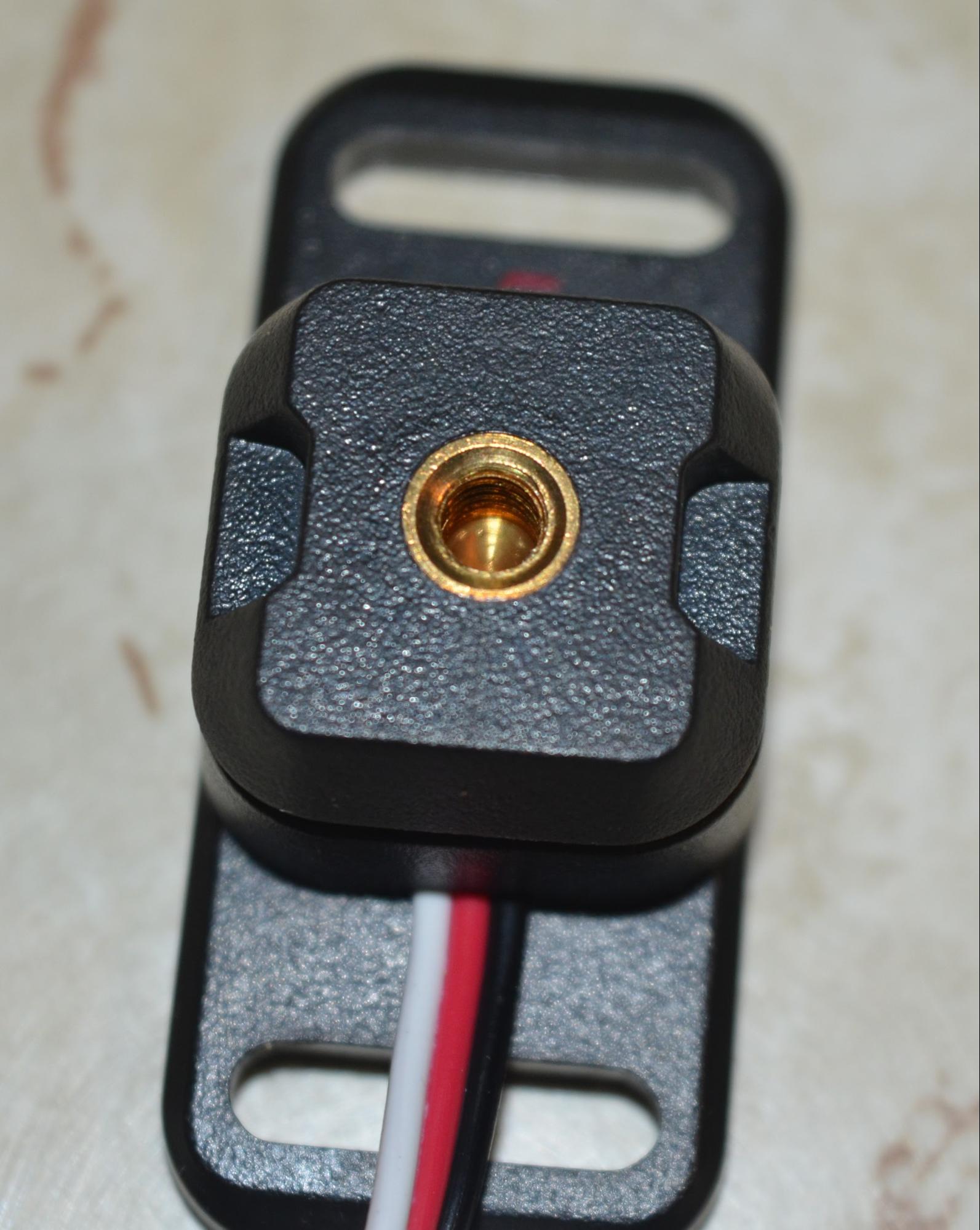 Close up of the Bumper Switch device after the Center Screw and the red bumper button have been removed. Underneath the button, there is a 8-32 Mounting Insert which can be used to attach other components to the sensor.