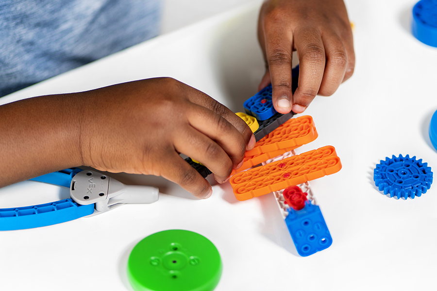 En elev som arbetar med VEX GO-element i en klassrumsmiljö.