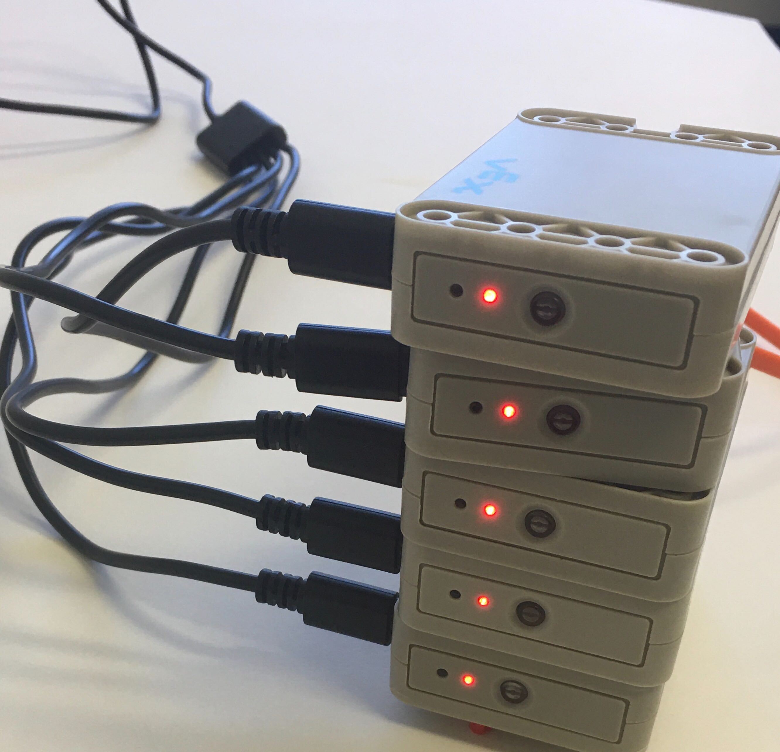 Stapel med GO-batterier som alla är inkopplade och laddas med VEX GO-batteriladdningskablarna.