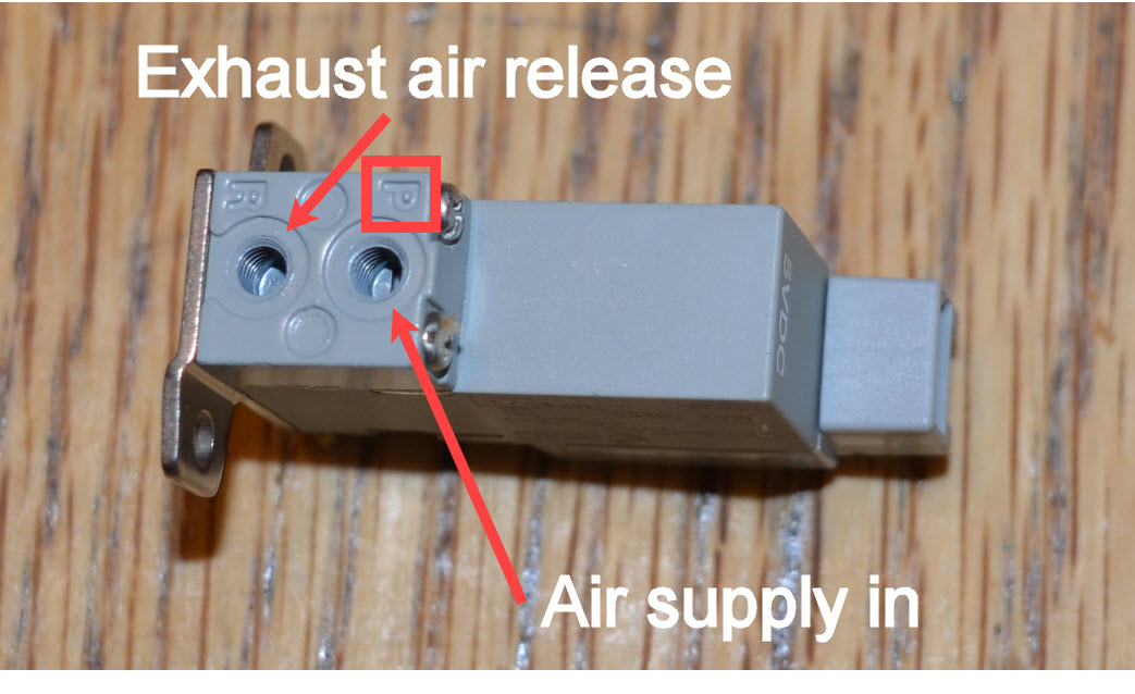 Diagram som illustrerar komponenterna och layouten för äldre pneumatik i V5-robotsystem, och visar olika delar och deras anslutningar för bättre förståelse av pneumatikens funktionalitet.