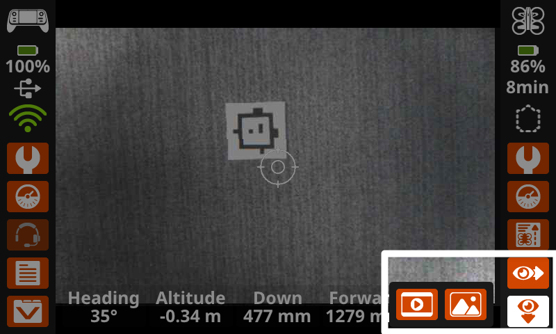 O ecrã do comando mostra uma vista da câmara virada para baixo no ecrã principal, com os botões "Olho" destacados no canto inferior direito, exibindo as opções para captar imagens do sensor de visão virado para baixo.