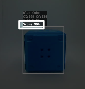 Close-up van een Blue Cube die door de AI Vision in het nutsbedrijf wordt gedetecteerd. Een markering markeert de tekst boven het object met de tekst score dubbele punt 99 procent.