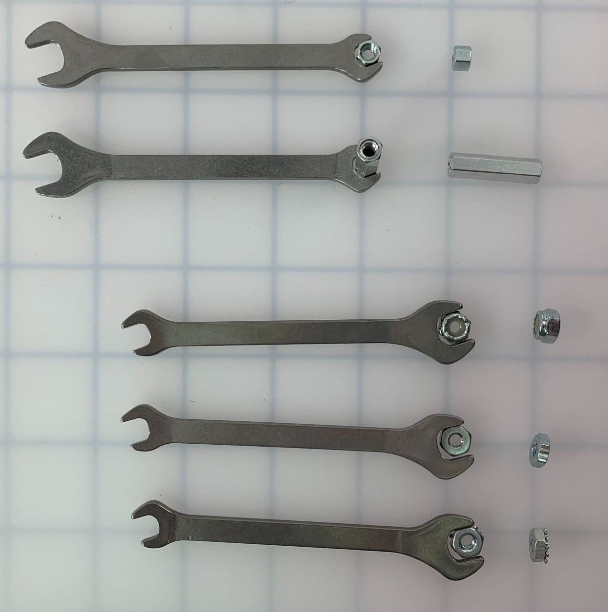 V5 Open End Wrench is shown holding various V5 pieces in its smaller end and its larger end. The smaller pieces include Low Profile Nuts and Standoffs, and the larger pieces include Nylock Nuts, Hex Nuts, and Keps Nuts.
