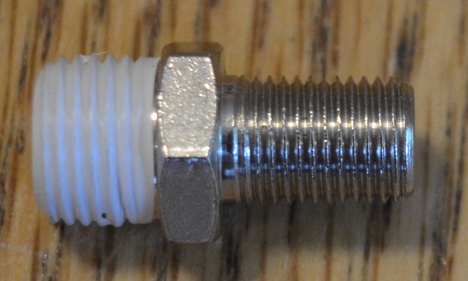 Tire pump fitting piece with a layer of Teflon tape wrapped around its threads for an airtight seal.