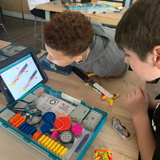 Two male students looking at build instructions to construct the VEX GO Adaptation Claw collaboratively.