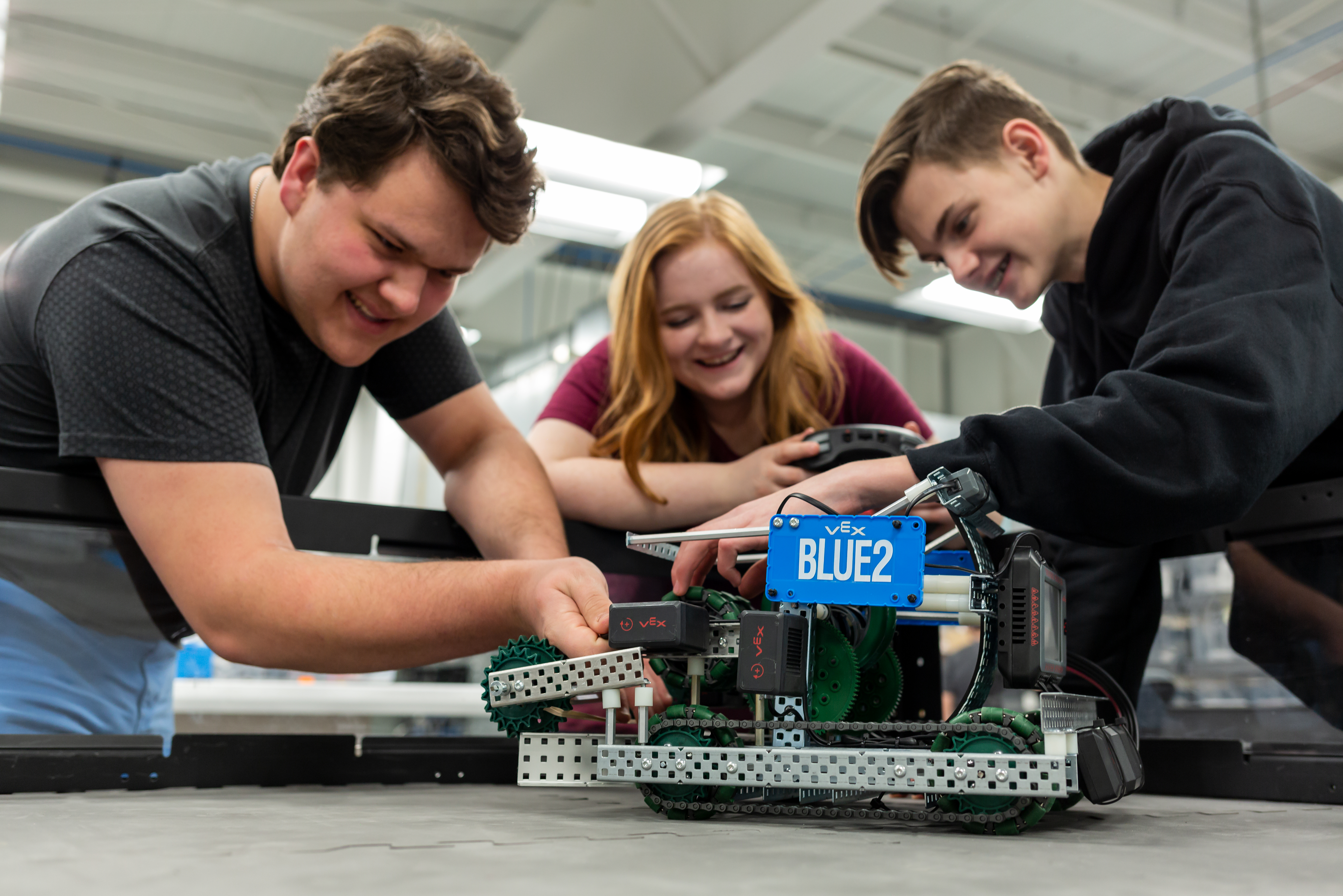 Students collaborating to build and program a V5 robot, demonstrating hands-on STEM learning and problem-solving.