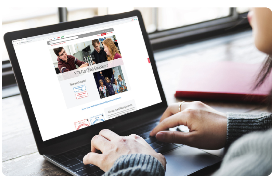 Educator is shown on a laptop engaging with the VEX Robotics community.