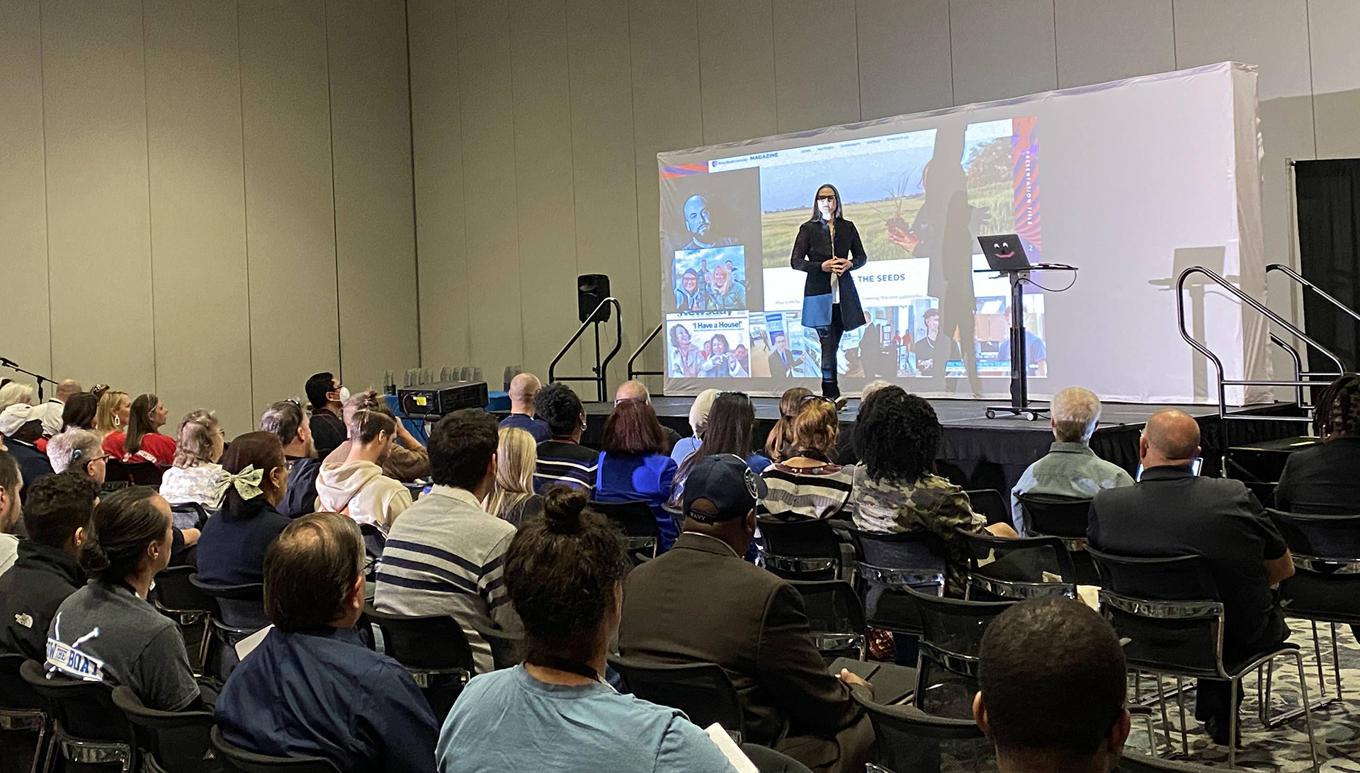 Photo taken at a VEX Educators Conference, showing a presenter in front of a projector screen speaking to an audience.