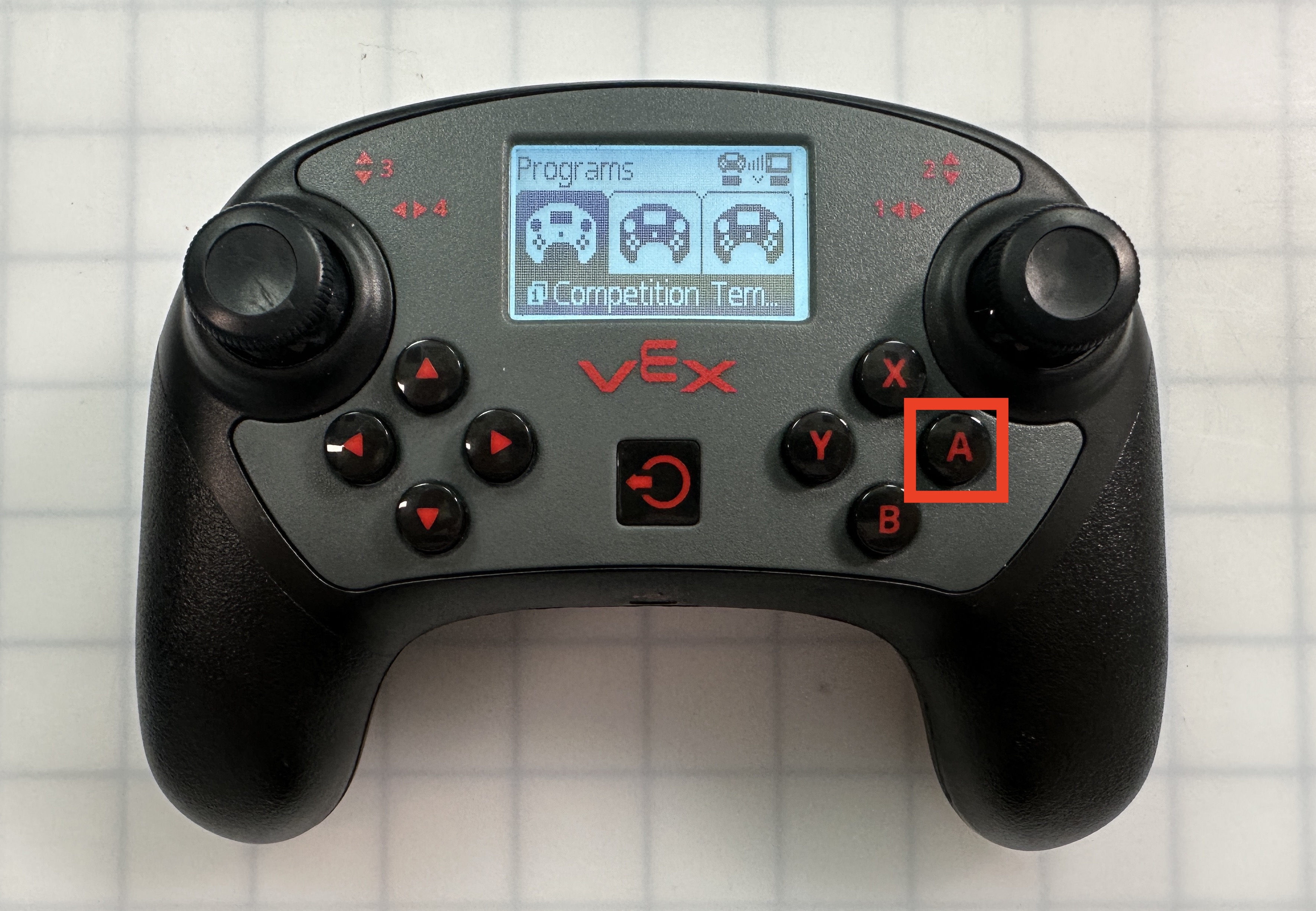 Nella figura è mostrato il controller V5 con il menu Programmi aperto e il progetto Modello di competizione selezionato. Il pulsante A è evidenziato.